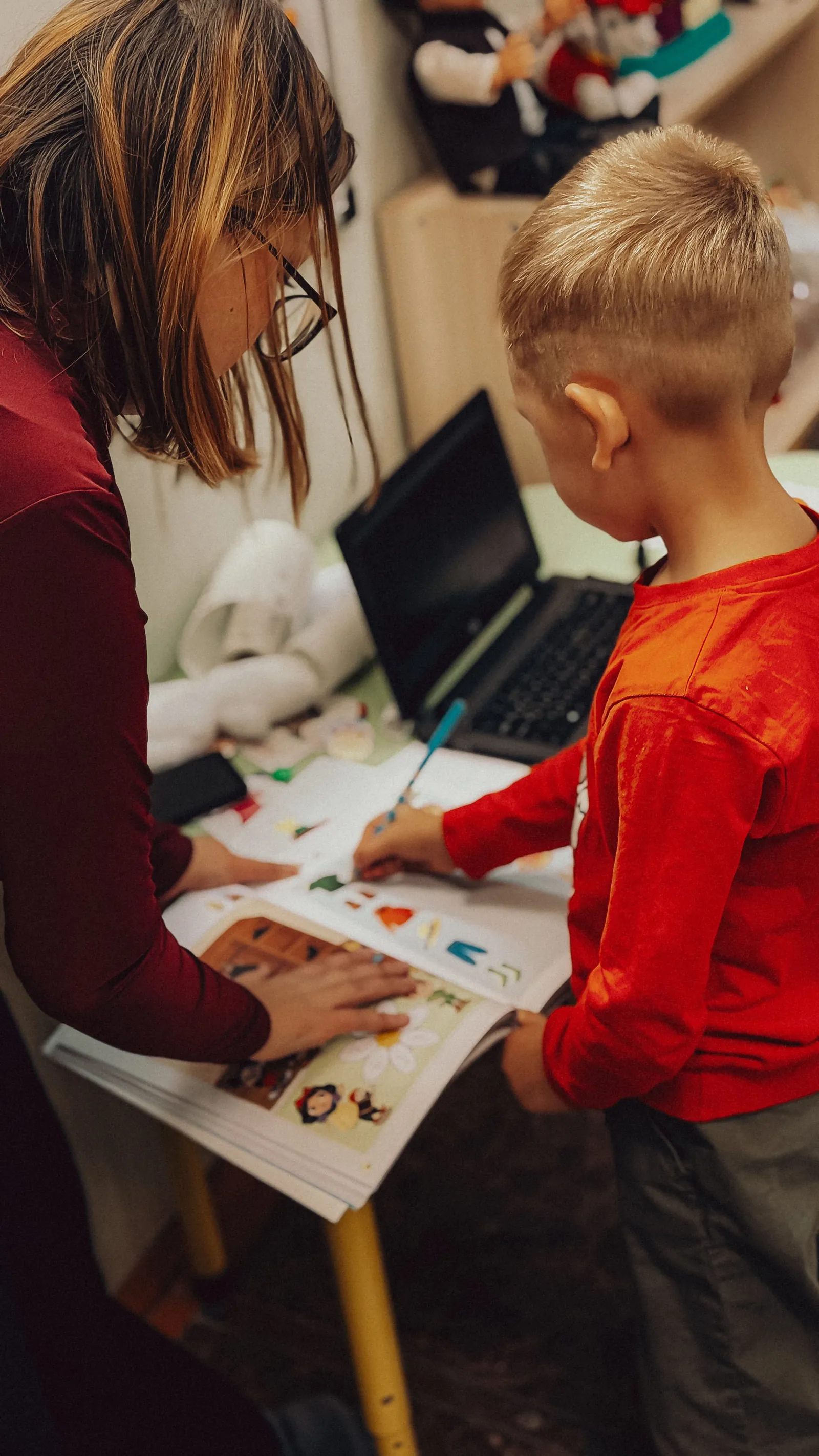 Teacher supporting a child with a structured learning activity