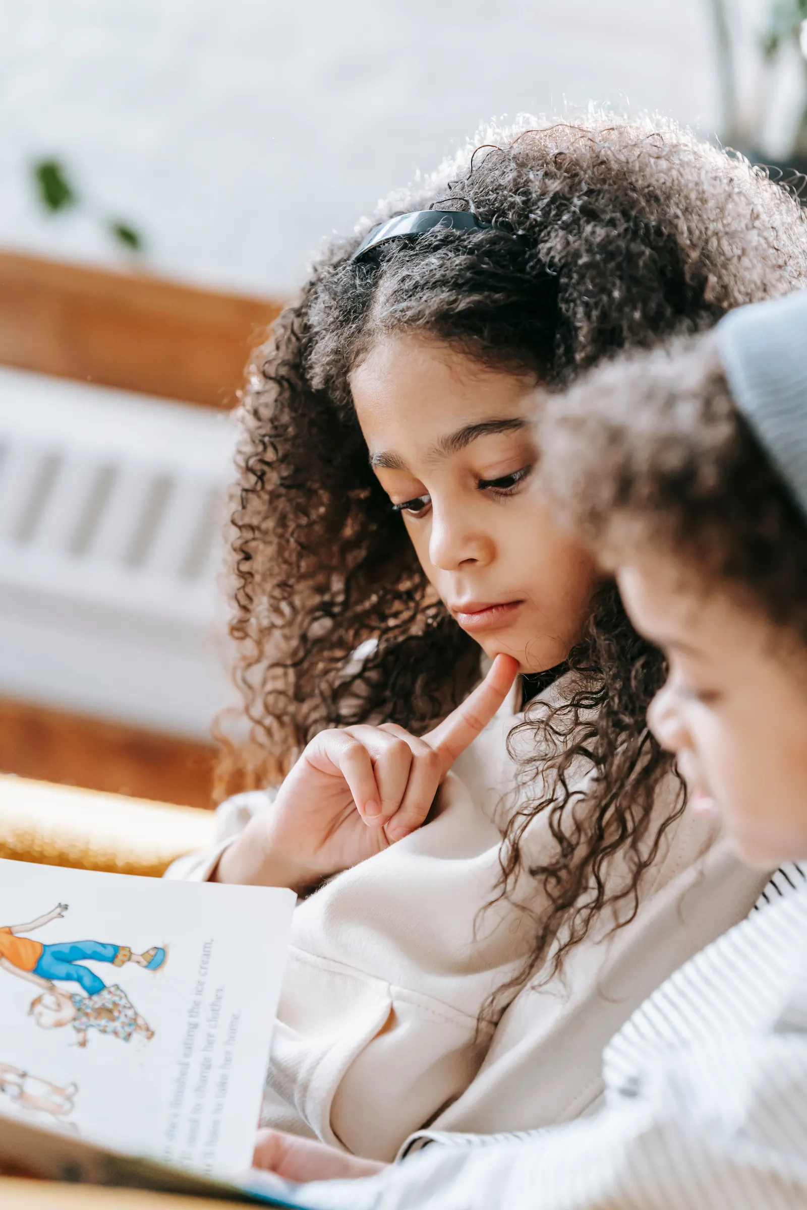 Children reading a picture storybook together with focused attention