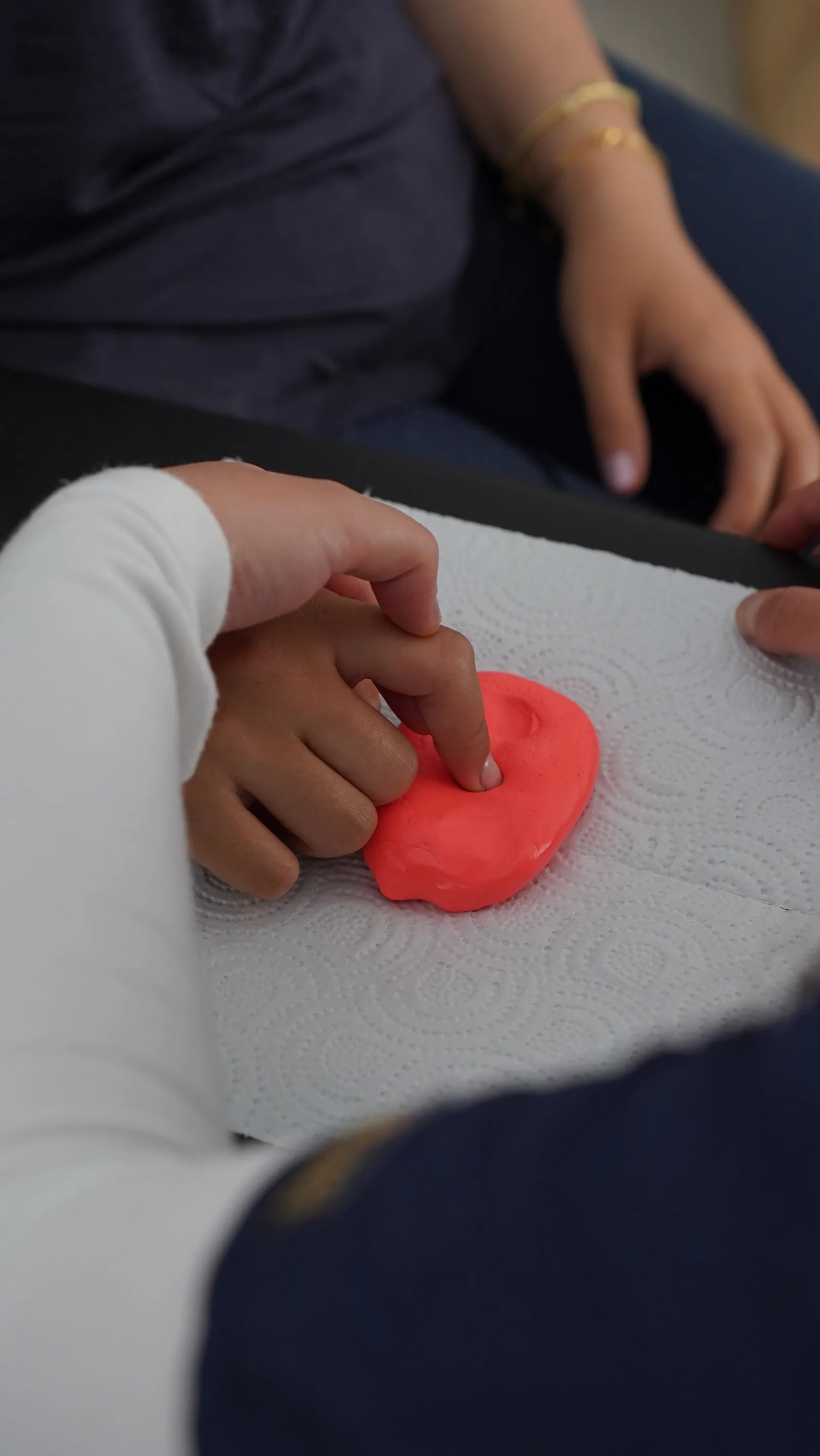 Child using modelling clay for a sensory and fine-motor activity
