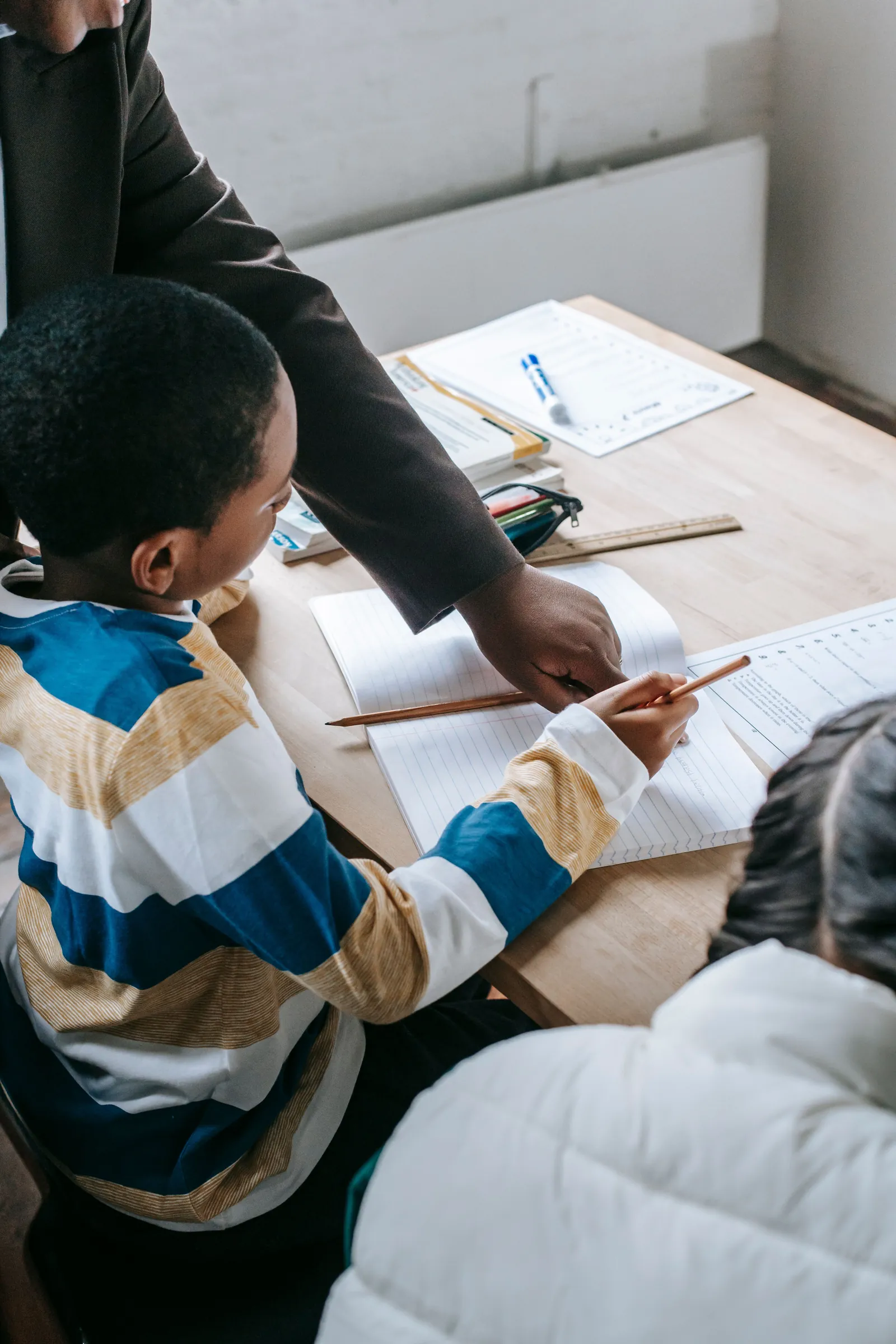 Educator supporting children with written classroom work